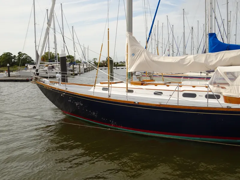 Slide: The Image of 1964 Hinckley Bermuda 40 Custom sailboat docked in a marina, featuring classic design and sleek lines. - 4