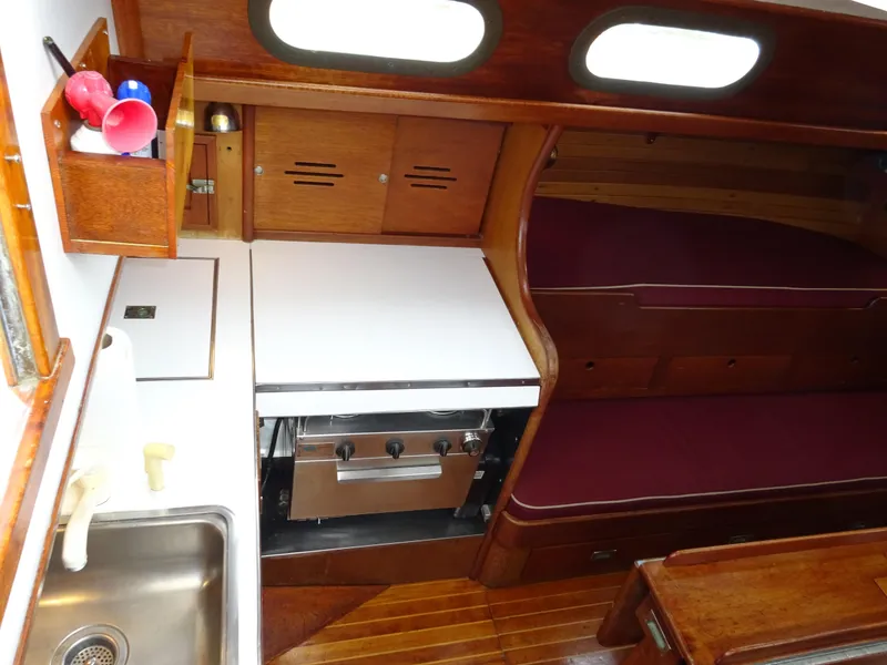 Slide: The Image of Interior of 1964 Hinckley Bermuda 40 Custom sailboat with wooden cabinetry and compact kitchen area. - 41