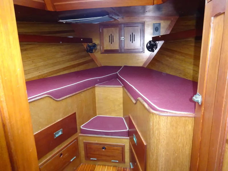 Slide: The Image of Interior of 1964 Hinckley Bermuda 40 Custom sailboat with wooden cabinetry and red cushions. - 43