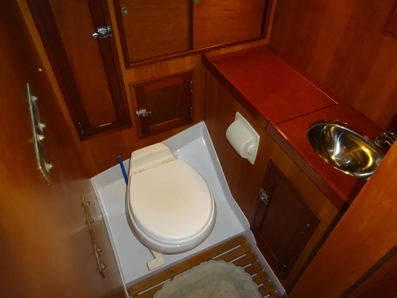 Slide: The Image of Hinckley Bermuda 40 Custom 1964 yacht bathroom with wooden cabinetry and compact fixtures. - 47
