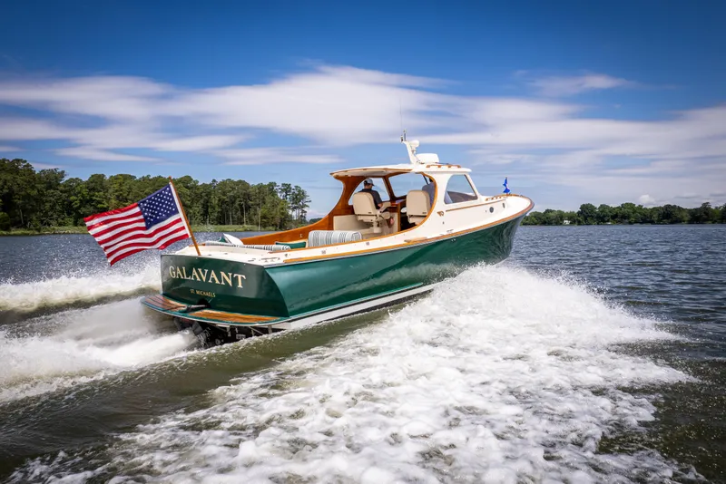 Slide: The Image of Hinckley Picnic Boat Classic 1997 cruising on a lake with American flag, clear sky. - 15