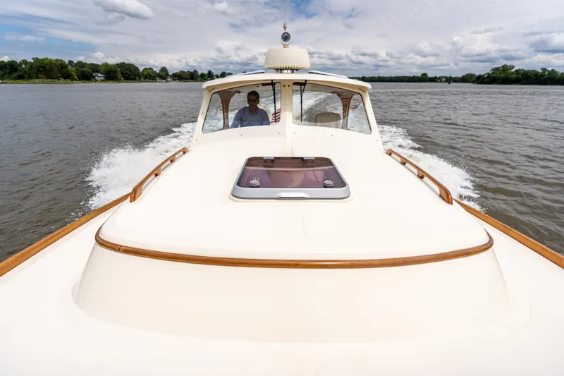 Slide: The Image of Hinckley Picnic Boat Classic 1997 cruising on a calm lake under a partly cloudy sky. - 19