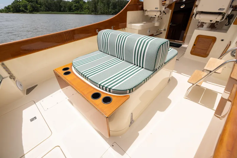 Slide: The Image of 1997 Hinckley Picnic Boat Classic with striped seating, wooden accents, and cup holders on deck. - 26