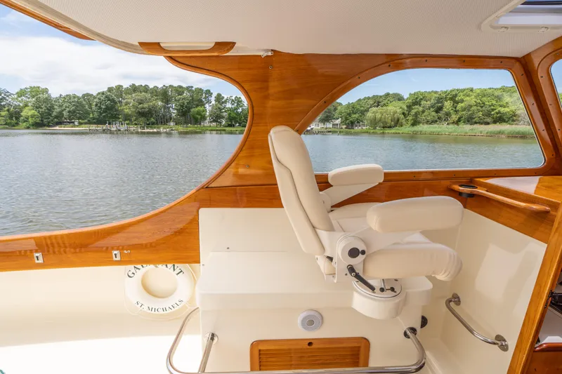 Slide: The Image of 1997 Hinckley Picnic Boat Classic interior with captain's chair, wooden accents, and scenic water view. - 29