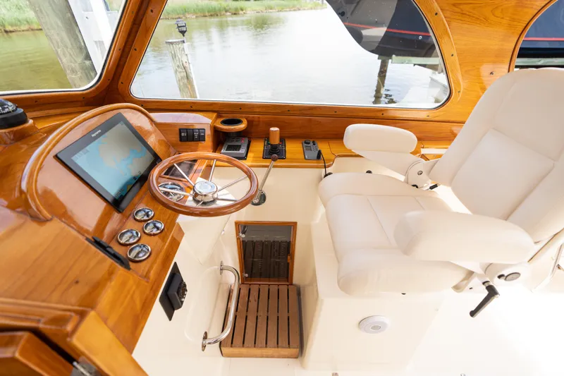 Slide: The Image of 1997 Hinckley Picnic Boat Classic helm with wooden dashboard and white captain's chair. - 32