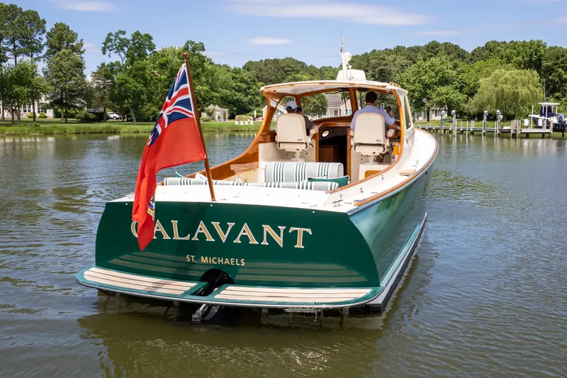 Slide: The Image of 1997 Hinckley Picnic Boat Classic on calm water, rear view with flag. - 9