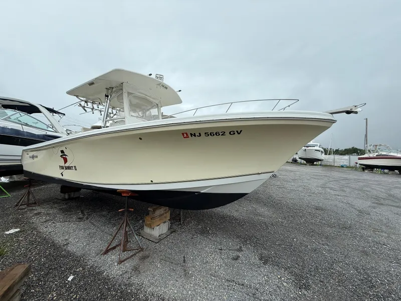 Slide: The Image of 2004 Sailfish 266 CC boat on stands in a gravel lot. - 1