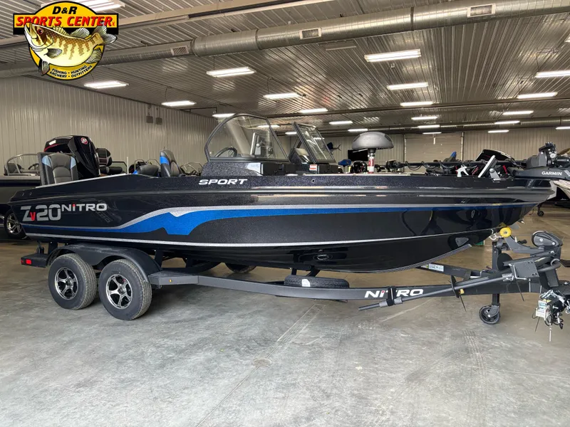 Slide: The Image of 2025 Nitro ZV20 Sport Pro boat in showroom, black with blue accents, on trailer. - 5