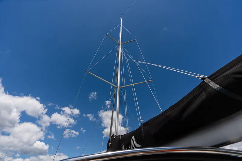 Slide: The Image of Mast of 2023 Hanse 348 sailboat against a clear blue sky with clouds. - 22