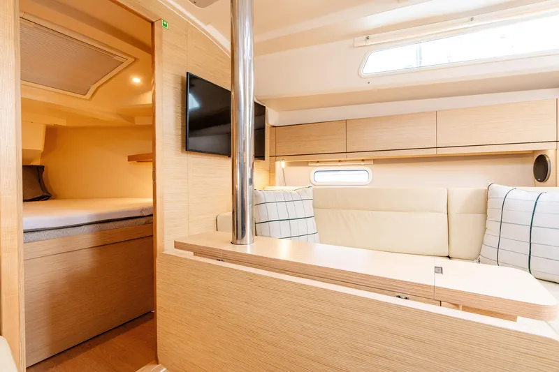 Slide: The Image of 2023 Hanse 348 yacht interior with modern seating, TV, and cozy cabin space. - 33