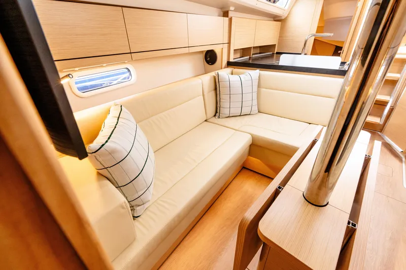 Slide: The Image of 2023 Hanse 348 yacht interior with beige seating, wooden finish, and modern design. - 34