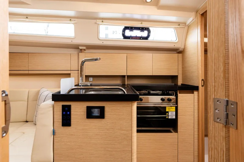 Slide: The Image of 2023 Hanse 348 yacht interior with modern kitchen, wooden cabinetry, and sleek design. - 44