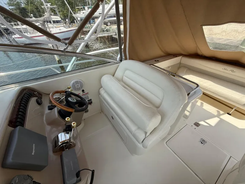 Slide: The Image of 2004 Sea Ray 290 Amberjack helm with leather seating and wooden steering wheel. - 13
