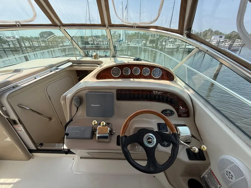 Slide: The Image of 2004 Sea Ray 290 Amberjack helm with steering wheel and control panel, docked at marina. - 14