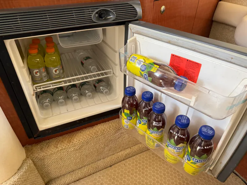 Slide: The Image of Mini fridge stocked with drinks inside a 2004 Sea Ray 290 Amberjack boat. - 28