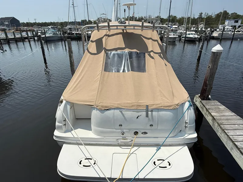 Slide: The Image of 2004 Sea Ray 290 Amberjack docked with beige cover, marina background. - 3