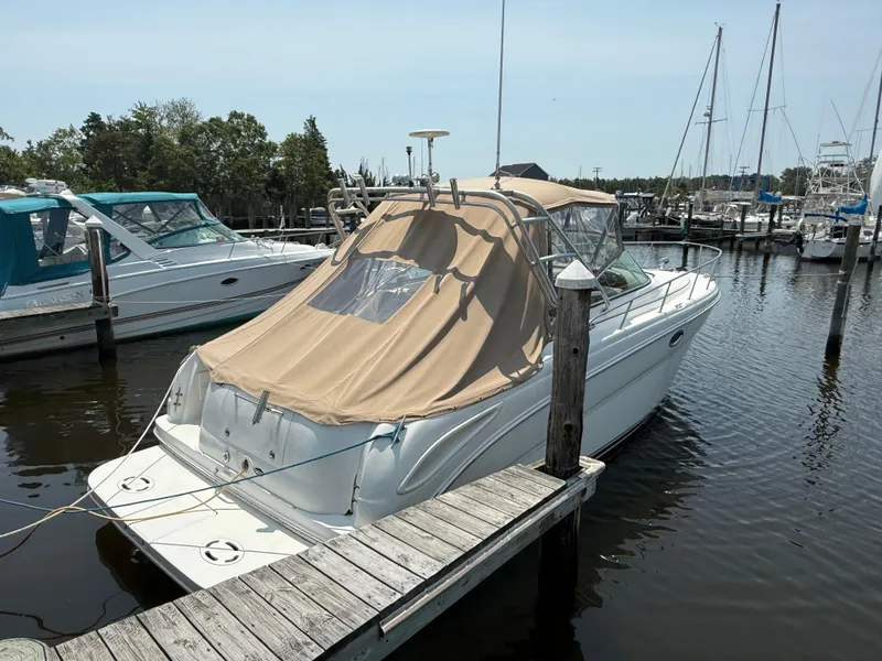 Slide: The Image of 2004 Sea Ray 290 Amberjack docked at a marina with beige cover. - 4