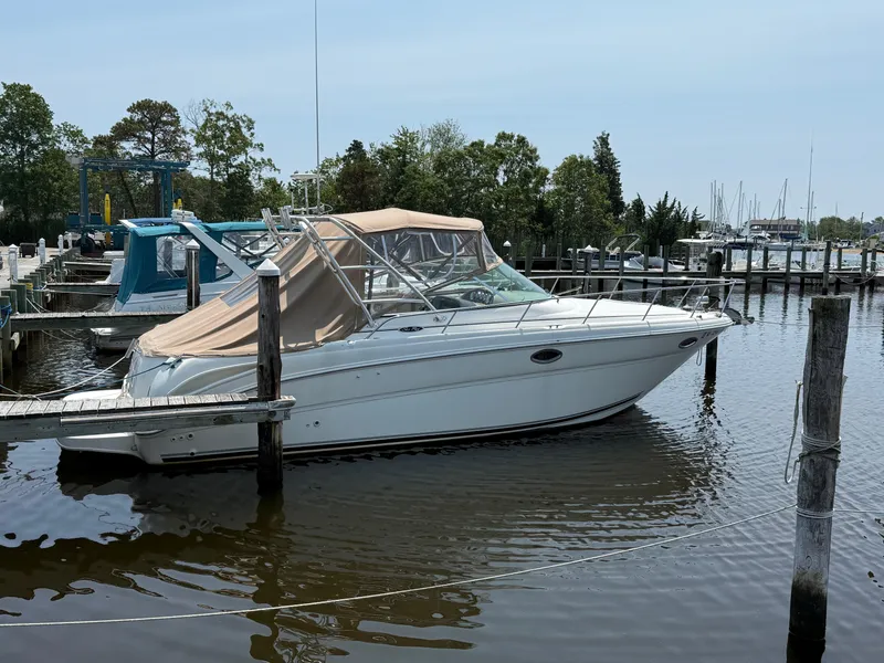 Slide: The Image of 2004 Sea Ray 290 Amberjack boat docked in a marina, surrounded by calm water and trees. - 5