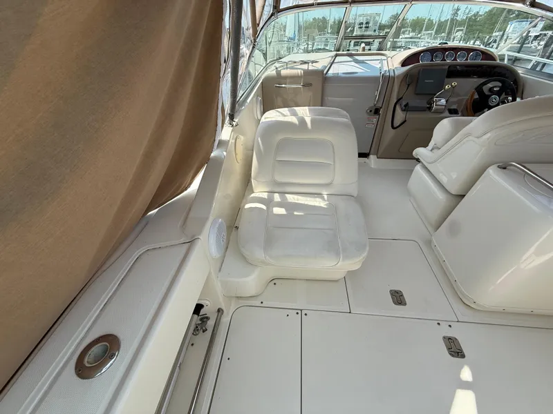 Slide: The Image of 2004 Sea Ray 290 Amberjack boat interior with white seating and control panel. - 8