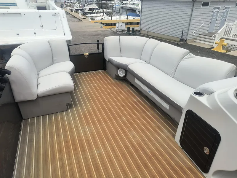 Slide: The Image of 2017 Godfrey Sweetwater Premium Edition 255 SBH boat with spacious seating and wood-patterned flooring. - 7