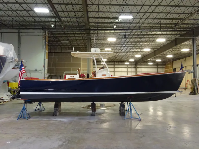 Slide: The Image of 2007 Hinckley T29C boat in a warehouse, elevated on stands, with an American flag. - 10