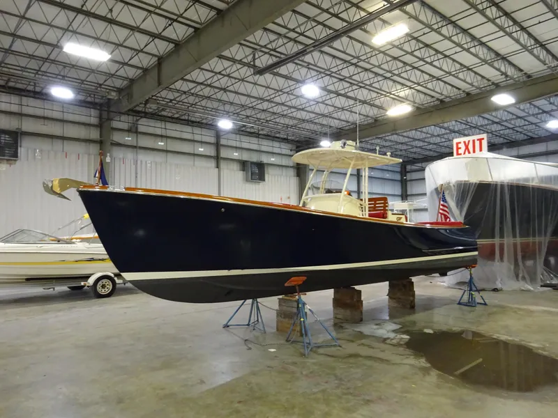 Slide: The Image of 2007 Hinckley T29C boat in indoor storage facility, elevated on stands. - 12