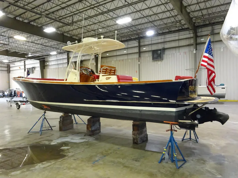 Slide: The Image of 2007 Hinckley T29C boat in a warehouse, elevated on stands, with an American flag. - 13