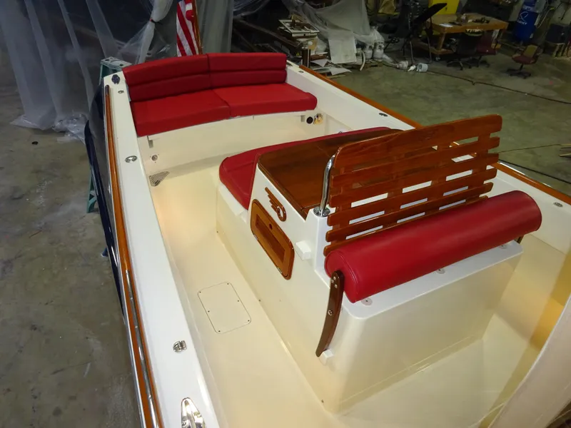 Slide: The Image of 2007 Hinckley T29C boat interior with red seating and wooden accents in a workshop. - 23