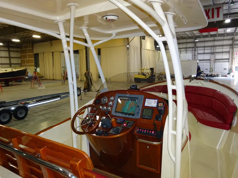 Slide: The Image of 2007 Hinckley T29C boat interior with navigation controls in a spacious warehouse setting. - 25