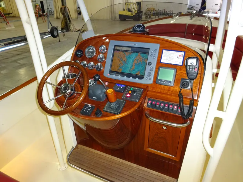 Slide: The Image of 2007 Hinckley T29C boat dashboard with navigation equipment and wooden steering wheel. - 26