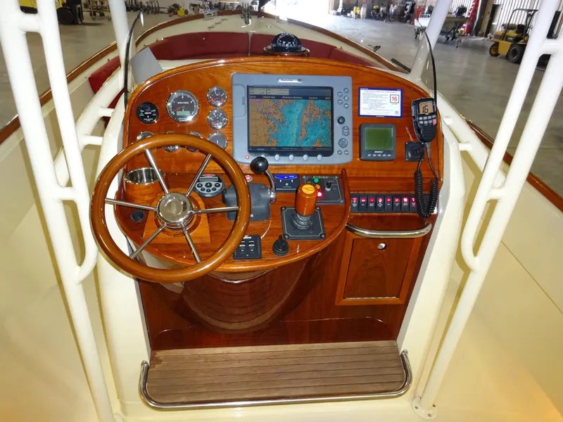 Slide: The Image of 2007 Hinckley T29C boat dashboard with wooden steering wheel and navigation equipment. - 27