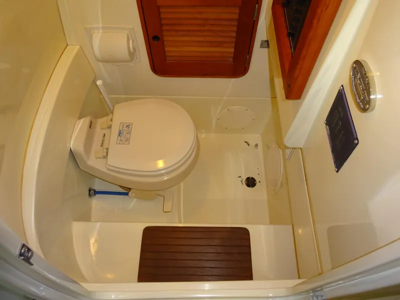 Slide: The Image of Hinckley T29C 2007 yacht bathroom with toilet, wooden accents, and compact design. - 30