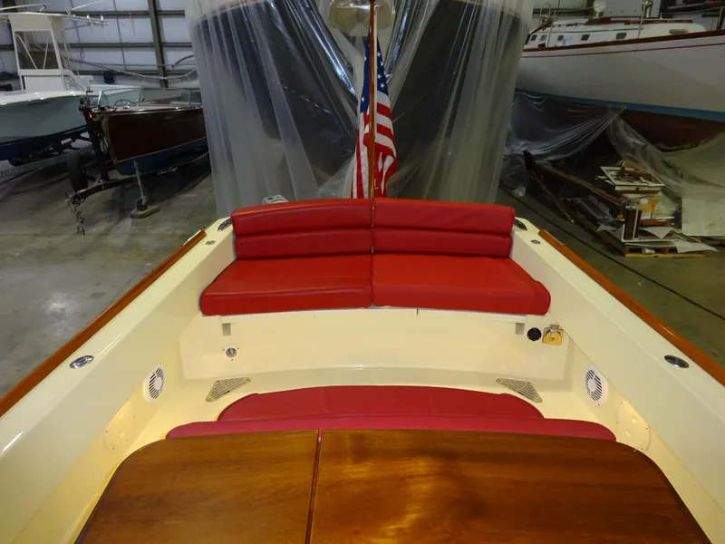 Slide: The Image of 2007 Hinckley T29C boat interior with red seating and American flag in a storage facility. - 31