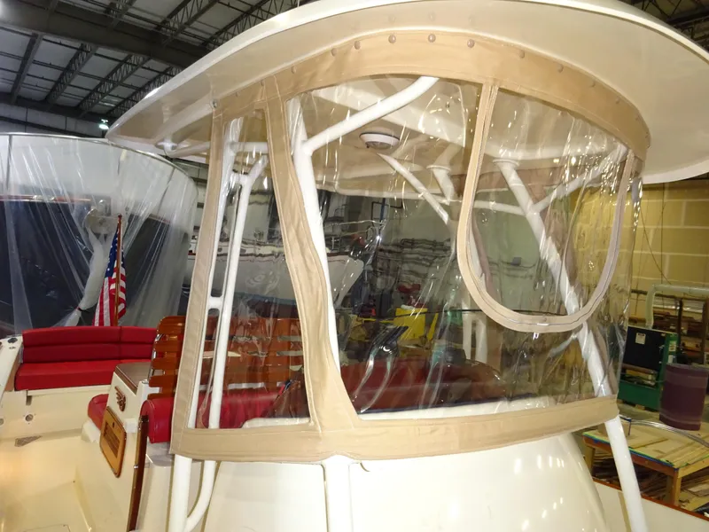 Slide: The Image of 2007 Hinckley T29C boat with clear enclosure and red seating in a warehouse. - 36