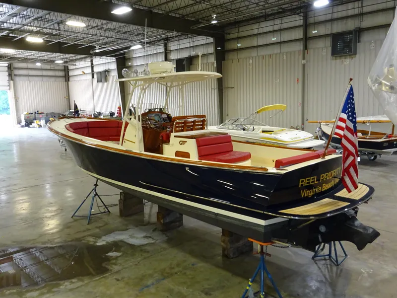 Slide: The Image of 2007 Hinckley T29C boat in a warehouse, featuring red seating and an American flag. - 4