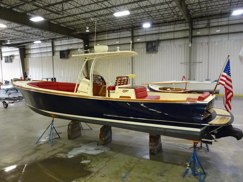 Slide: The Image of 2007 Hinckley T29C boat in warehouse, blue hull, red interior, American flag displayed. - 5