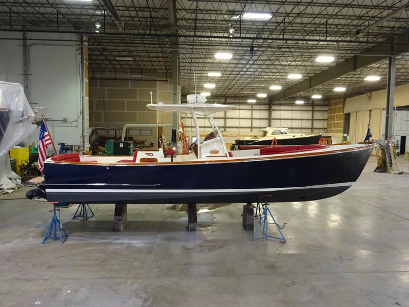 Slide: The Image of 2007 Hinckley T29C boat in warehouse, elevated on stands, with American flag. - 8