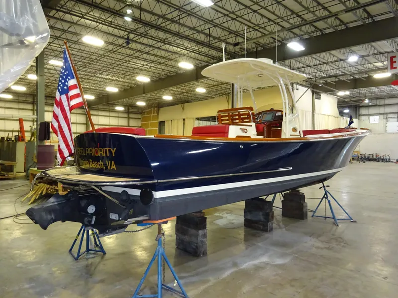 Slide: The Image of 2007 Hinckley T29C boat in warehouse, American flag, elevated on stands. - 9