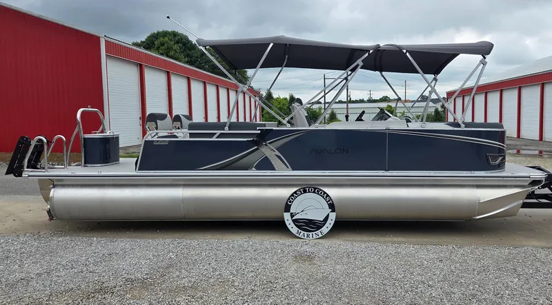 Slide: The Image of 2025 Avalon Platinum LSZ 2585 Quad Lounger Shift pontoon boat, parked near red storage units. - 1