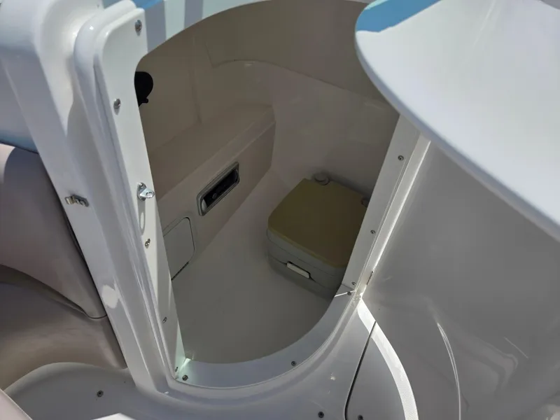 Slide: The Image of 2014 Hurricane SunDeck 2200 OB boat interior with storage compartment and portable toilet. - 19
