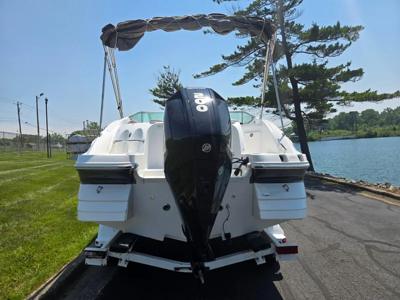 Slide: The Image of 2014 Hurricane SunDeck 2200 OB boat with outboard motor, parked near a lake. - 2