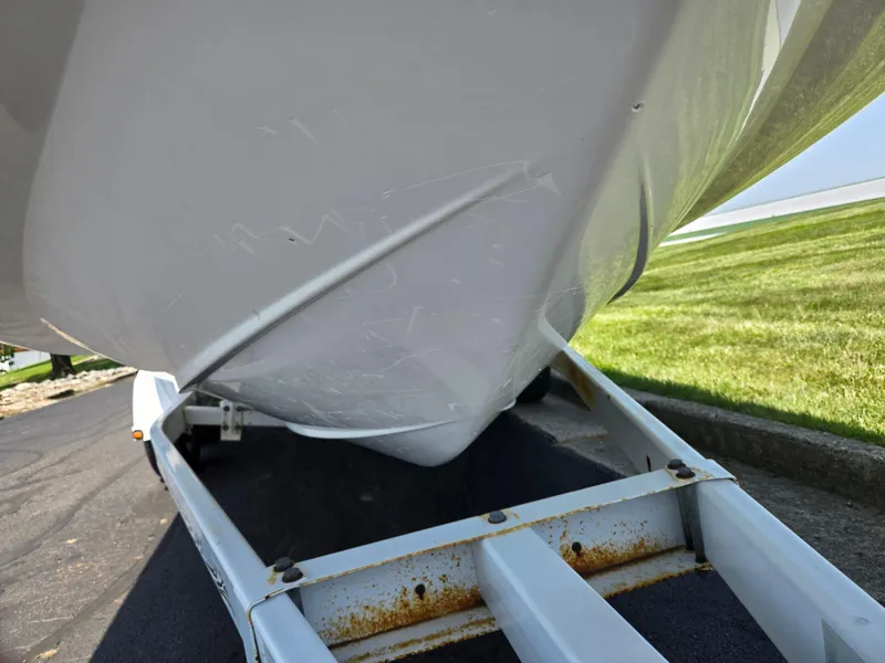 Slide: The Image of 2014 Hurricane SunDeck 2200 OB boat on trailer, showing hull and grassy background. - 7