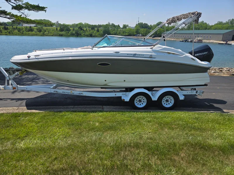 Slide: The Image of 2014 Hurricane SunDeck 2200 OB boat on trailer by a lake. - 9
