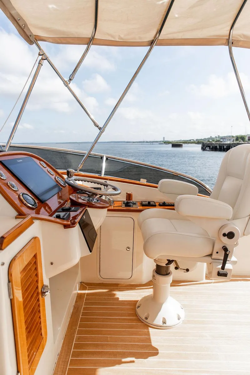 Slide: The Image of Flybridge helm of 2017 Hinckley Talaria 43, featuring luxurious seating and navigation controls. - 15