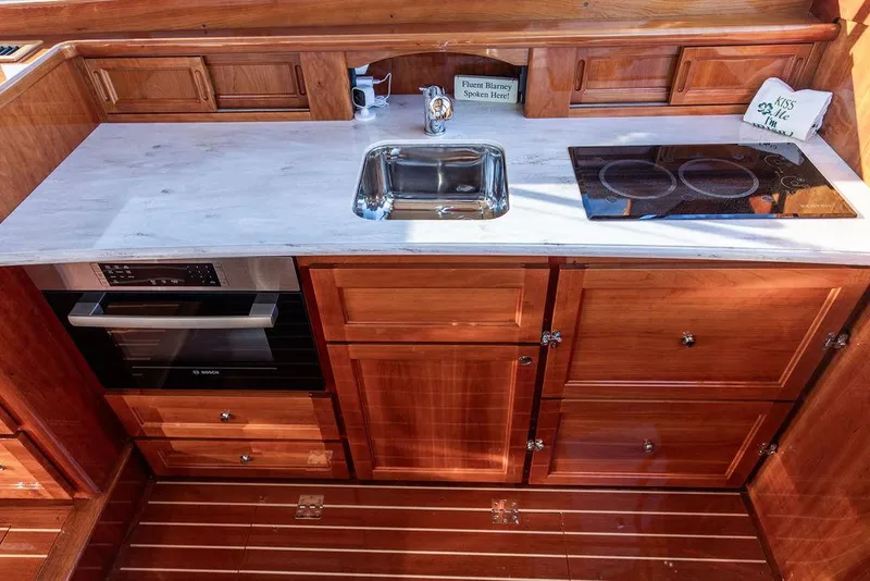 Slide: The Image of Luxurious 2017 Hinckley Talaria 43 Flybridge kitchen with wood cabinetry and modern appliances. - 27