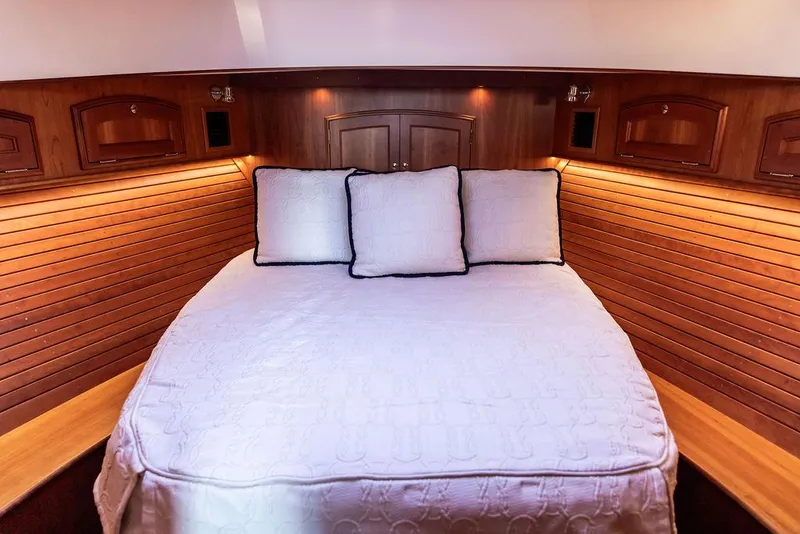 Slide: The Image of Luxurious cabin interior of 2017 Hinckley Talaria 43 Flybridge with cozy bedding and wood paneling. - 29
