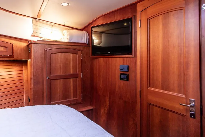 Slide: The Image of Luxurious wood interior of 2017 Hinckley Talaria 43 Flybridge yacht cabin with TV and storage. - 30