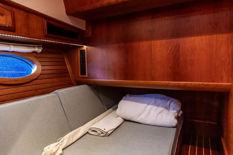 Slide: The Image of Cozy cabin interior of 2017 Hinckley Talaria 43 Flybridge with wooden paneling and porthole. - 32