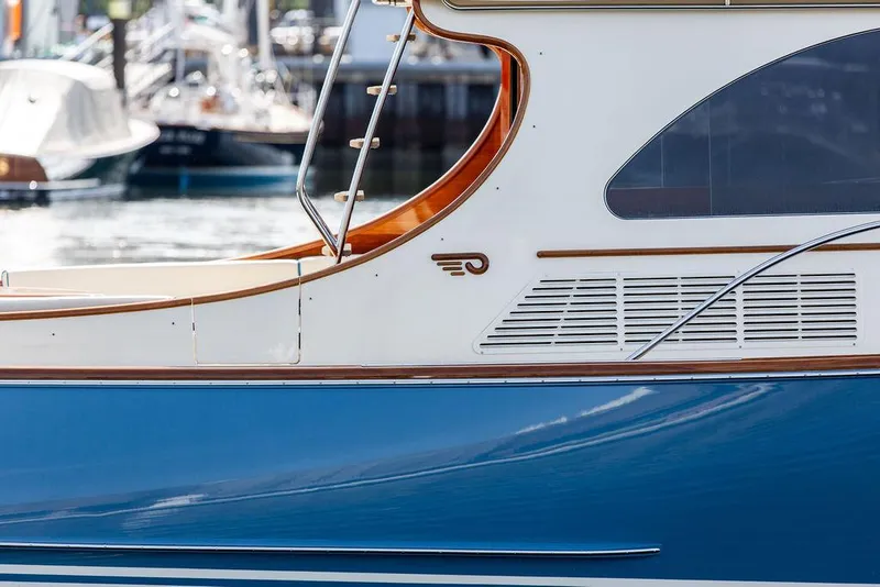 Slide: The Image of 2017 Hinckley Talaria 43 Flybridge yacht, blue and white exterior, docked at marina. - 34
