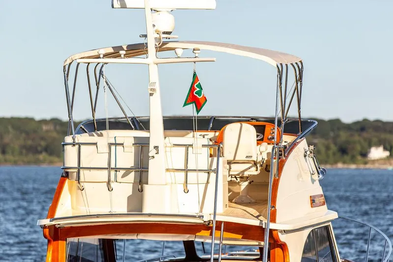 Slide: The Image of 2017 Hinckley Talaria 43 Flybridge yacht on calm water, showcasing elegant design and flybridge. - 4